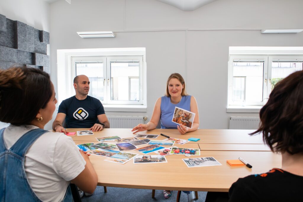 Symbolbild für Vielfalt im Unternehmen: Welche der 4 Personen am Tisch ist "neuronormal" und wer vielleicht "neurodivergent" bzw. "neurodivers"?