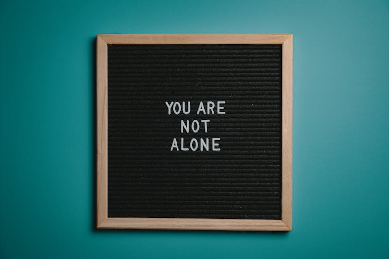 A wooden letter board displays a motivational message against a teal background.